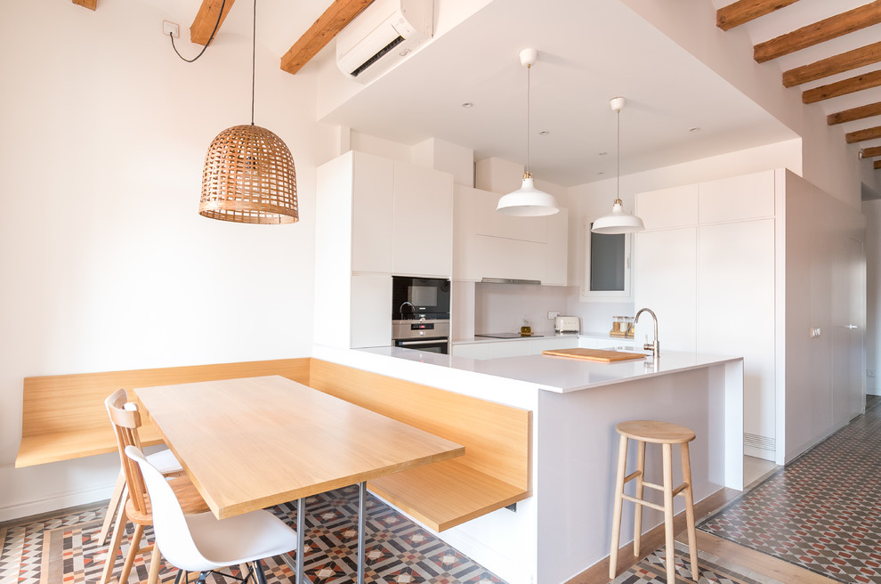Scandinavian eat-in kitchen in Other with an undermount sink, flat-panel cabinets, white cabinets, white splashback, panelled appliances, a peninsula, multi-coloured floor and white benchtop.