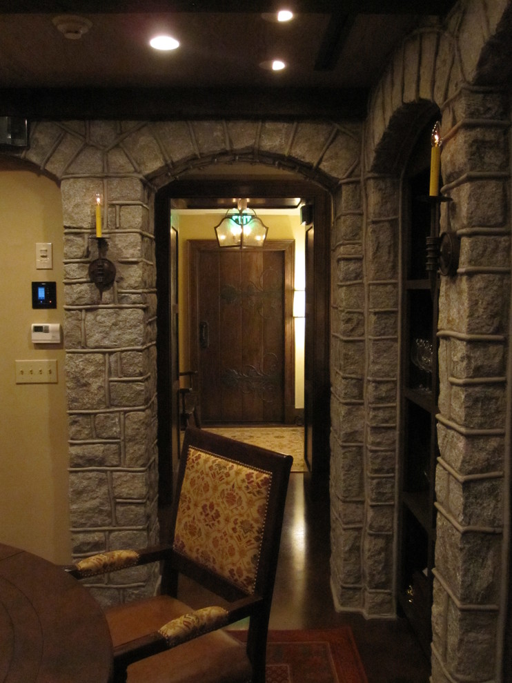 Example of a large mountain style concrete floor wine cellar design with storage racks
