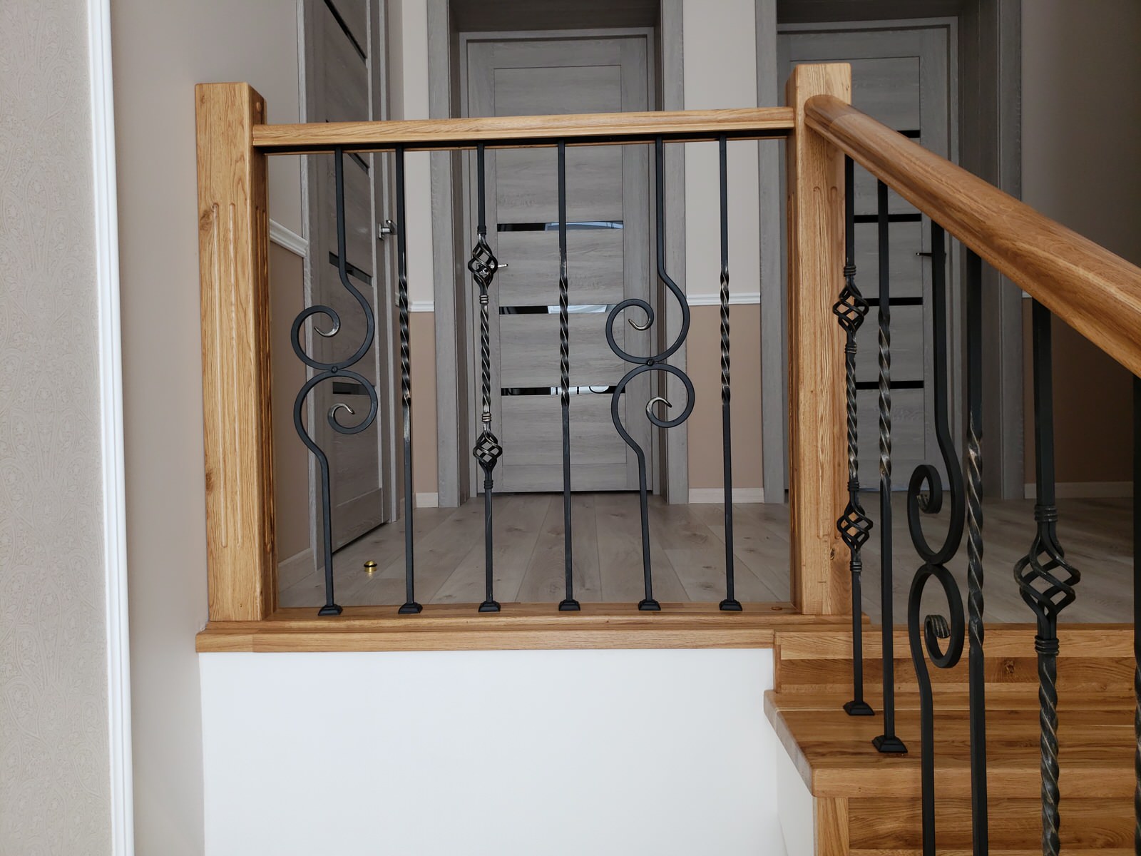 Лестница из дуба с коваными ограждениями