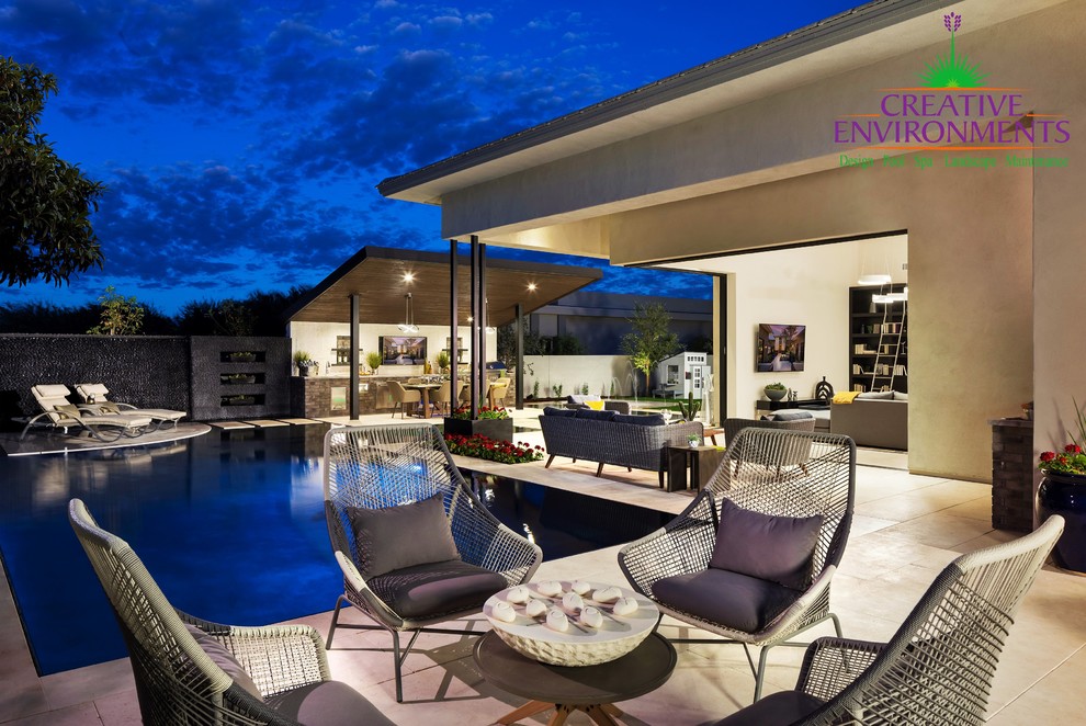 Pool fountain - large modern backyard stamped concrete and custom-shaped pool fountain idea in Phoenix