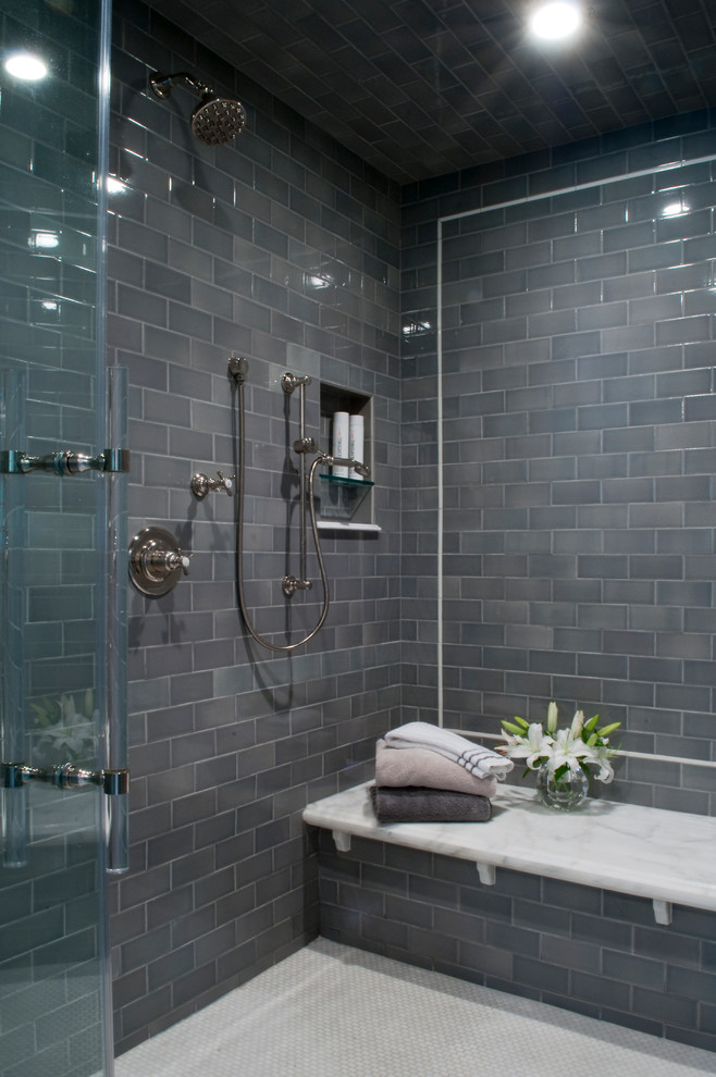 This is an example of an expansive transitional master bathroom in New York with a double shower, gray tile, glass tile, ceramic floors, white floor, a hinged shower door, a shower seat and wallpaper.