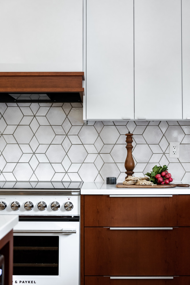 Design ideas for a midcentury l-shaped kitchen/diner in Minneapolis with white cabinets, engineered stone countertops, grey splashback, mosaic tiled splashback, white appliances and white worktops.