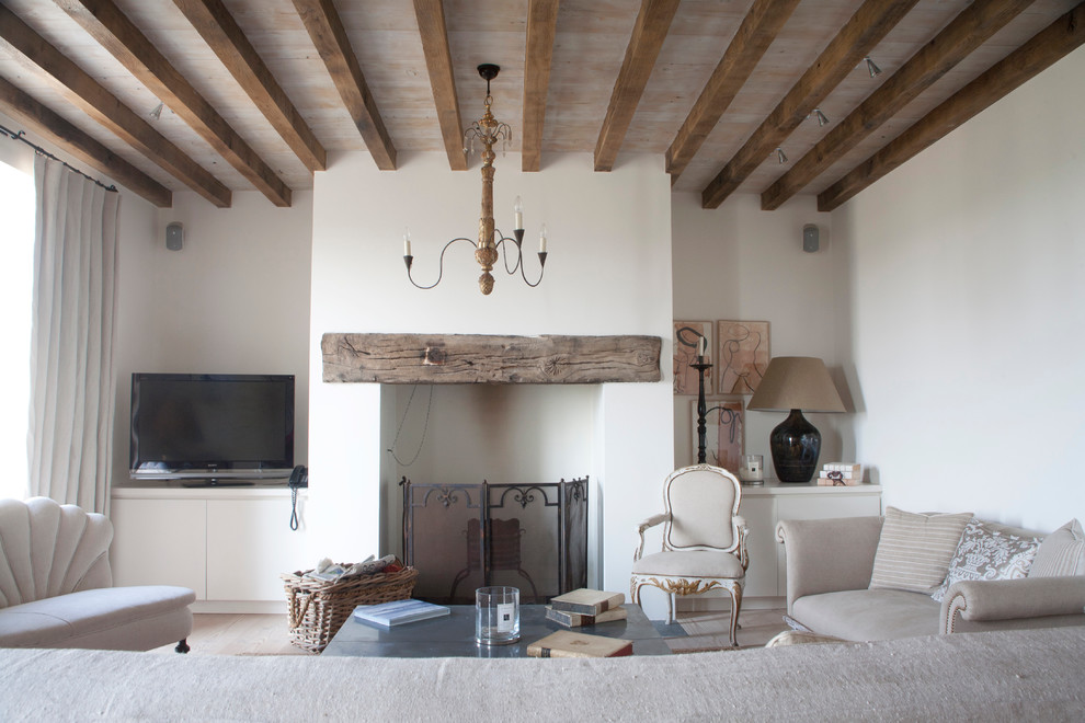 This is an example of a country formal living room in London with white walls and a standard fireplace.