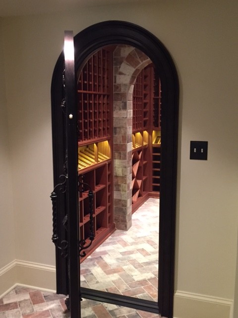 Mid-sized traditional wine cellar in Atlanta with terra-cotta floors, display racks and brown floor.