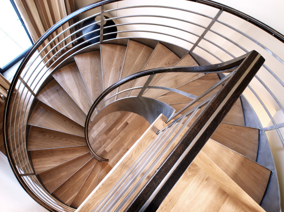 Photo of a contemporary wood spiral staircase in New York with open risers.