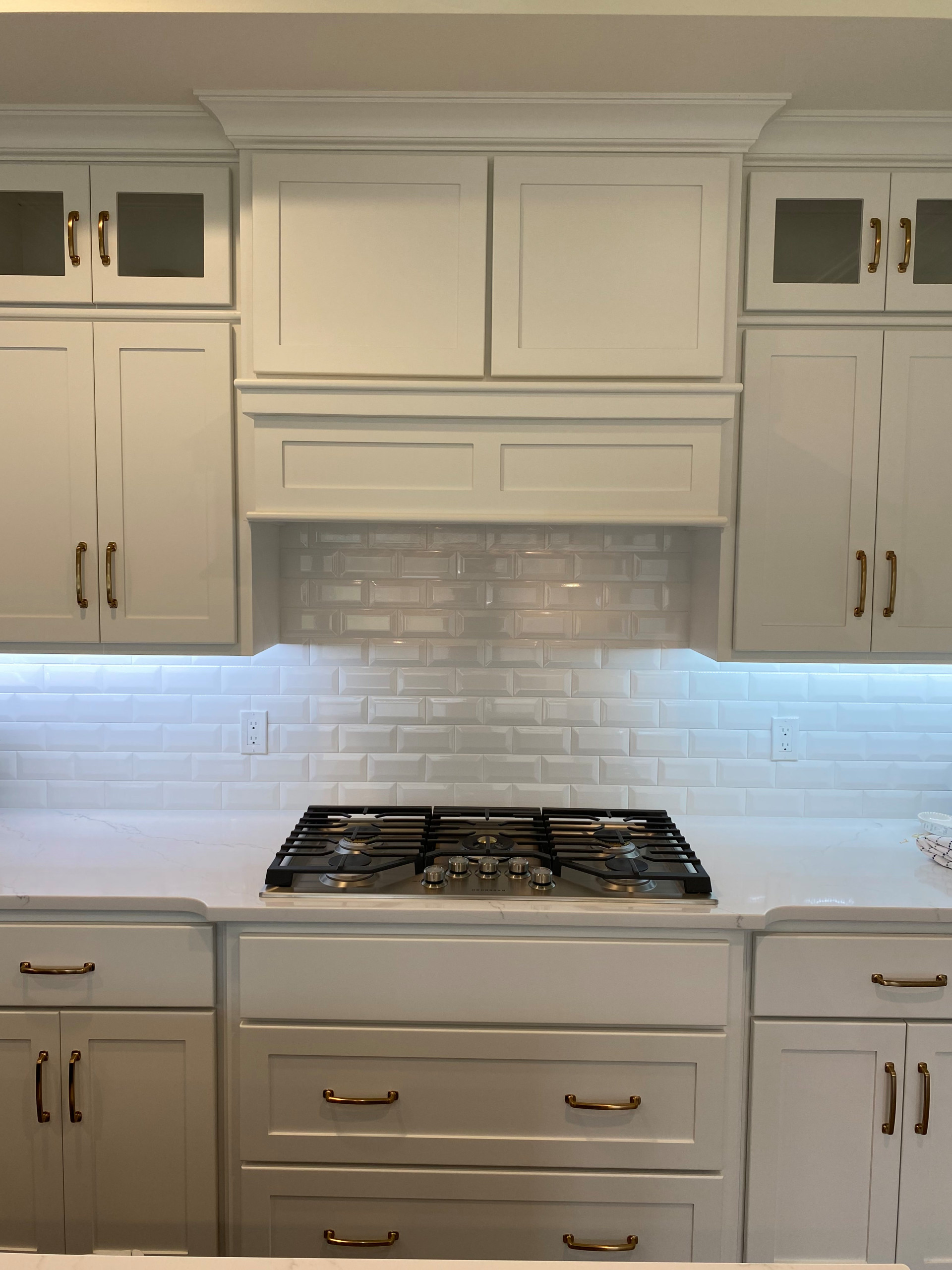 Custom kitchen painted cabinetry with subway tile, custom vent hood and gas cook