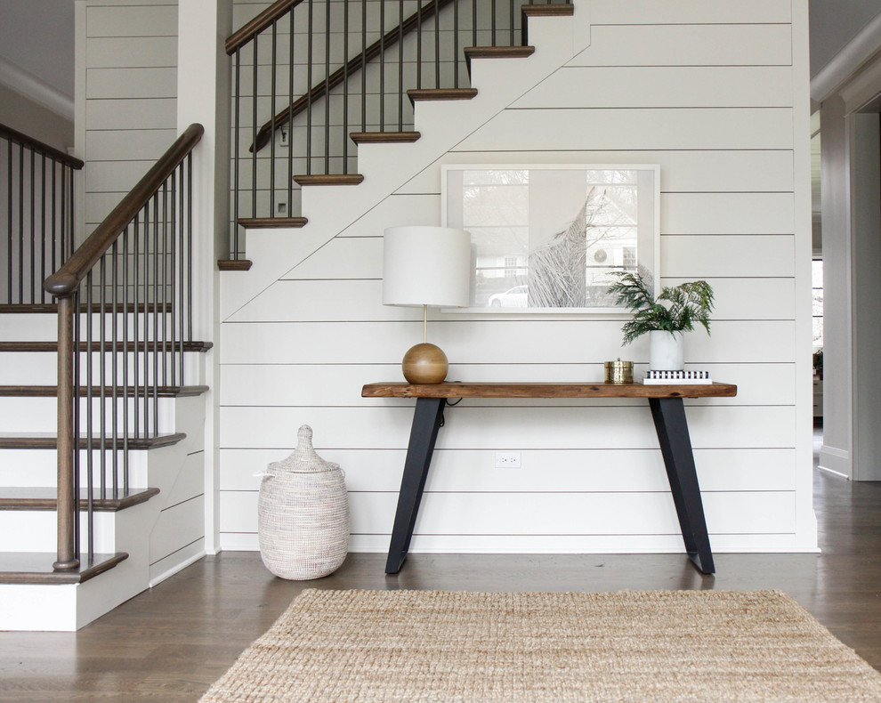 Example of a mid-sized transitional medium tone wood floor and brown floor foyer design in Chicago with white walls