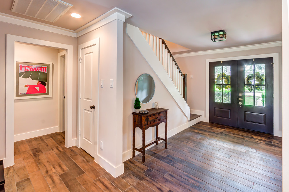 Photo of a mid-sized transitional foyer in Houston with grey walls, porcelain floors, a double front door, a gray front door and brown floor.