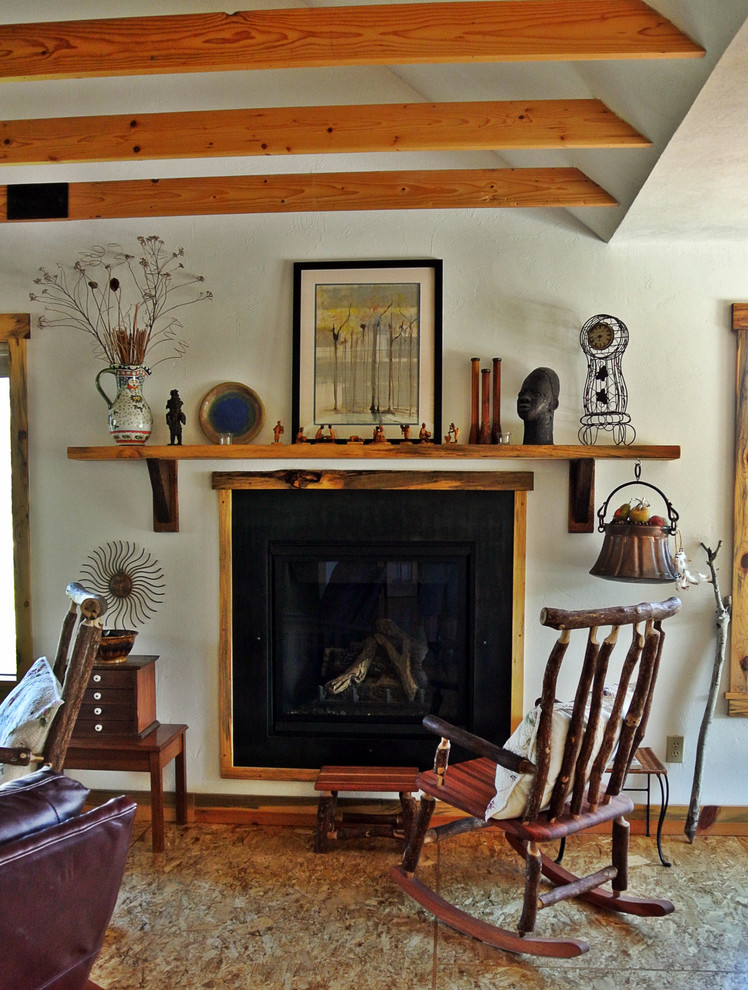 This is an example of an eclectic living room in Albuquerque with plywood floors and a standard fireplace.