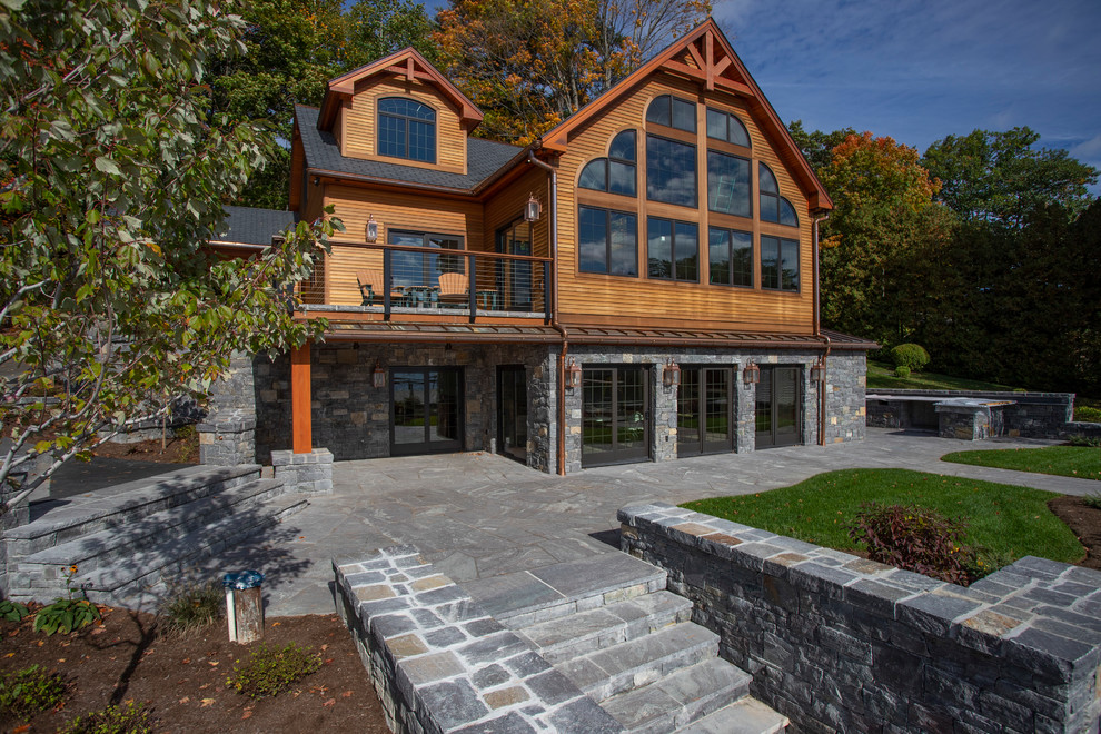 Design ideas for a large country two-storey brown house exterior in Boston with stone veneer.