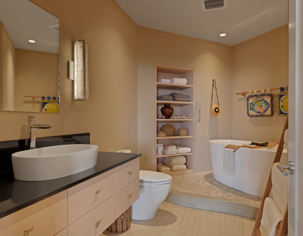Large contemporary master bathroom in Burlington with flat-panel cabinets, light wood cabinets, a freestanding tub, a two-piece toilet, beige walls, light hardwood floors, a vessel sink and onyx benchtops.
