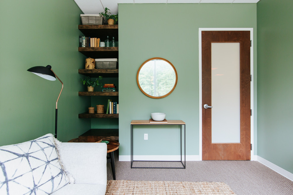 Cette image montre un très grand bureau minimaliste avec un mur vert et un sol marron.