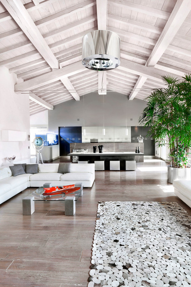 Design ideas for a contemporary open concept living room in Milan with medium hardwood floors and grey walls.