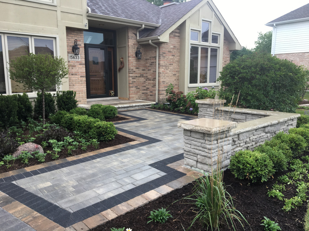 Photo of a large traditional front yard driveway in Chicago with with path and brick pavers.