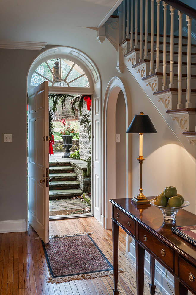 Traditional entryway in Philadelphia with a white front door and grey walls.
