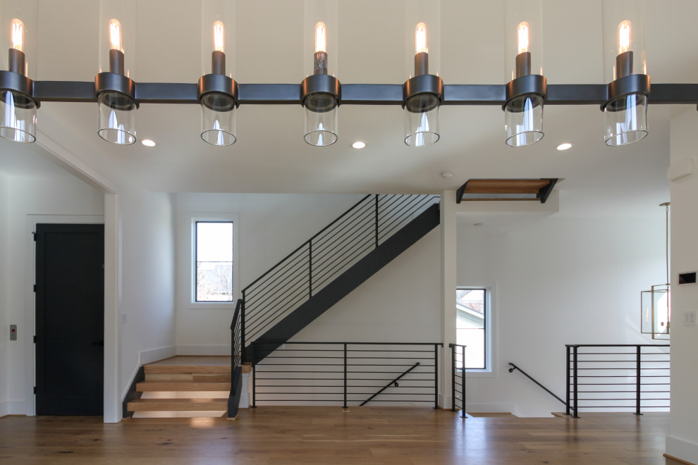 Foto de escalera recta contemporánea de tamaño medio con escalones de madera y barandilla de metal
