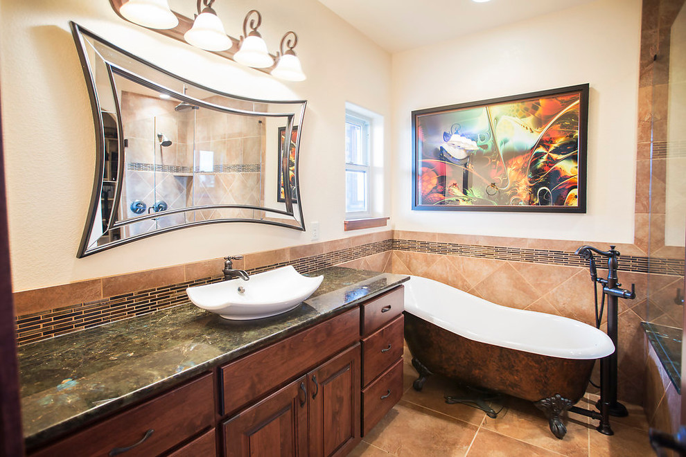 Photo of a mid-sized eclectic master bathroom in Denver with a vessel sink, raised-panel cabinets, medium wood cabinets, granite benchtops, a claw-foot tub, an alcove shower, a two-piece toilet, beige tile, ceramic tile, white walls and ceramic floors.