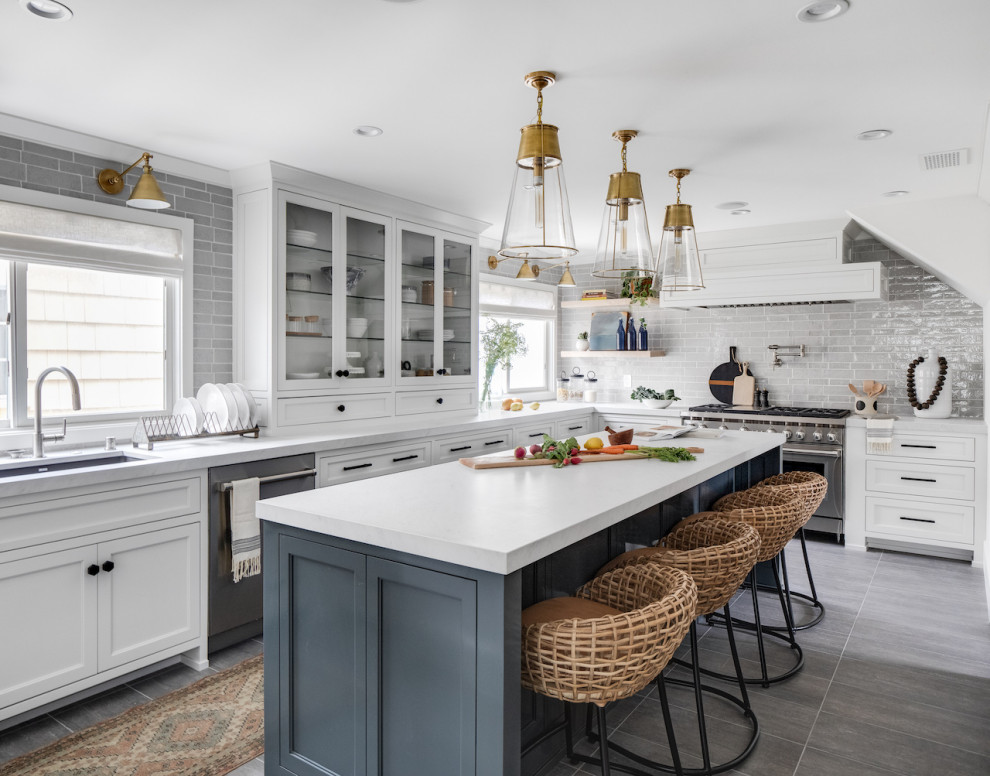 Design ideas for a transitional l-shaped kitchen in Orange County with an undermount sink, recessed-panel cabinets, white cabinets, grey splashback, stainless steel appliances, with island, grey floor and white benchtop.