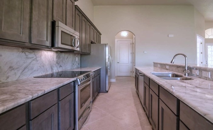 Inspiration for a mid-sized transitional galley ceramic tile open concept kitchen remodel in Miami with an undermount sink, shaker cabinets, gray cabinets, granite countertops, multicolored backsplash, stone slab backsplash, stainless steel appliances and an island