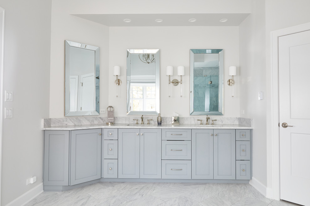 Inspiration for a large transitional master bathroom in Chicago with beaded inset cabinets, grey cabinets, a freestanding tub, a corner shower, a one-piece toilet, white tile, mirror tile, white walls, an undermount sink, quartzite benchtops, a hinged shower door, grey benchtops, a double vanity, a built-in vanity, marble floors, grey floor, a shower seat and vaulted.
