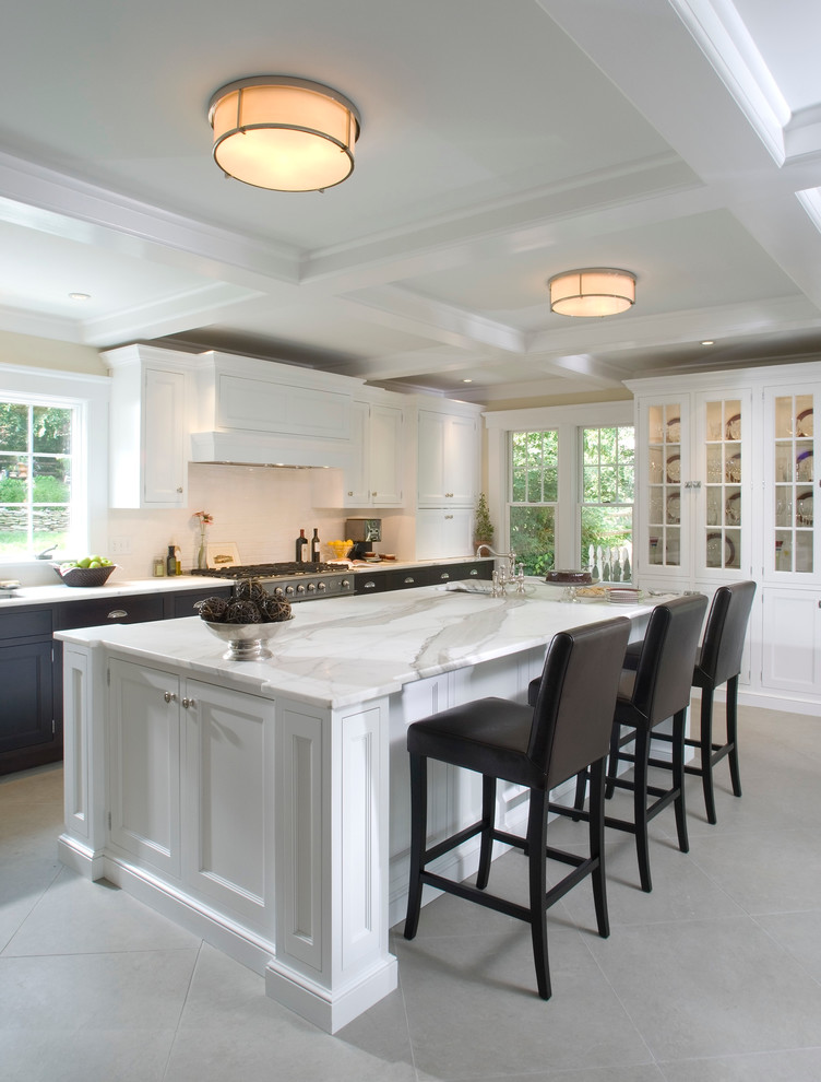 Traditional u-shaped eat-in kitchen in New York with an undermount sink, flat-panel cabinets, white cabinets, marble benchtops, ceramic splashback and stainless steel appliances.