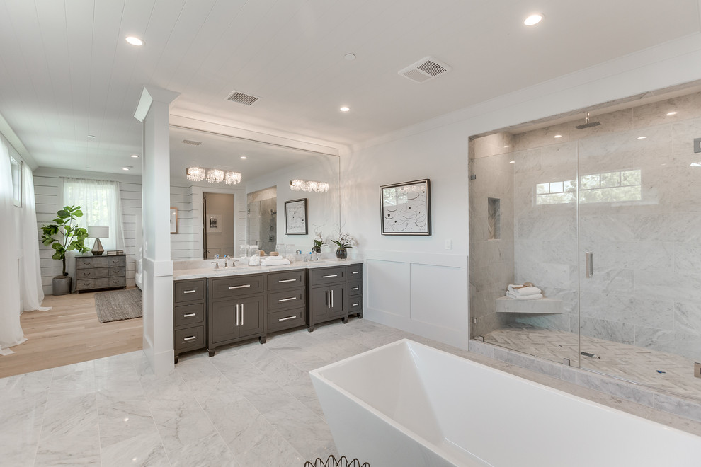 Design ideas for a large contemporary master bathroom in Los Angeles with shaker cabinets, grey cabinets, a freestanding tub, an alcove shower, gray tile, marble, white walls, marble floors, a drop-in sink, marble benchtops, white floor and a hinged shower door.