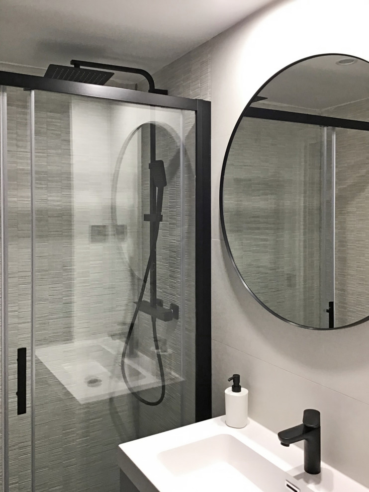 Exempel på ett mellanstort modernt badrum med dusch, med luckor med upphöjd panel, vita skåp, en kantlös dusch, ett urinoar, grå kakel, grå väggar, laminatgolv, grått golv och dusch med skjutdörr