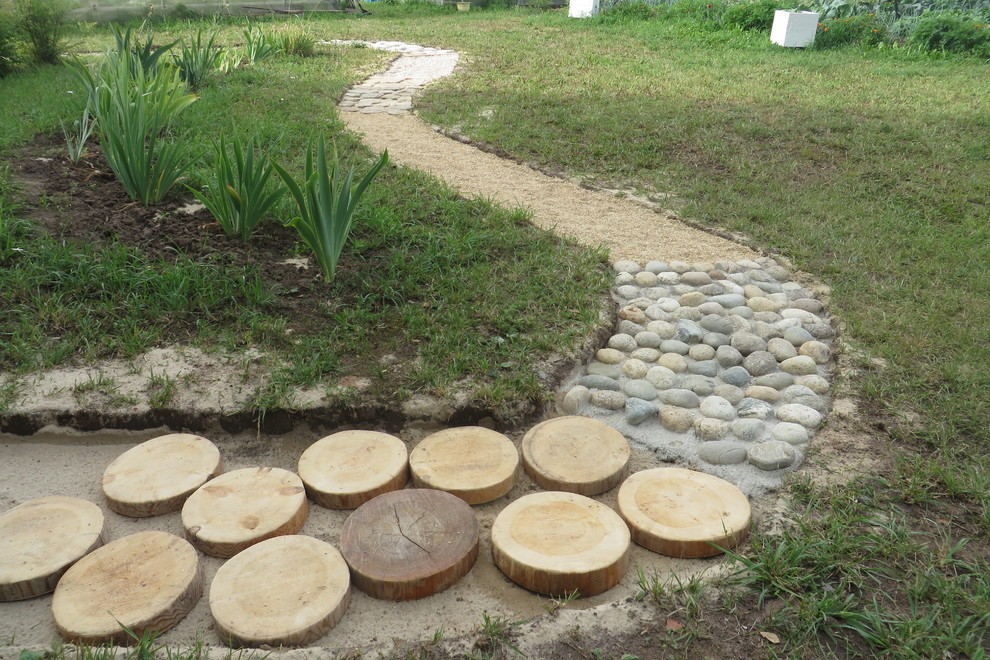 Стильный дизайн: большой участок и сад на переднем дворе с покрытием из каменной брусчатки - последний тренд