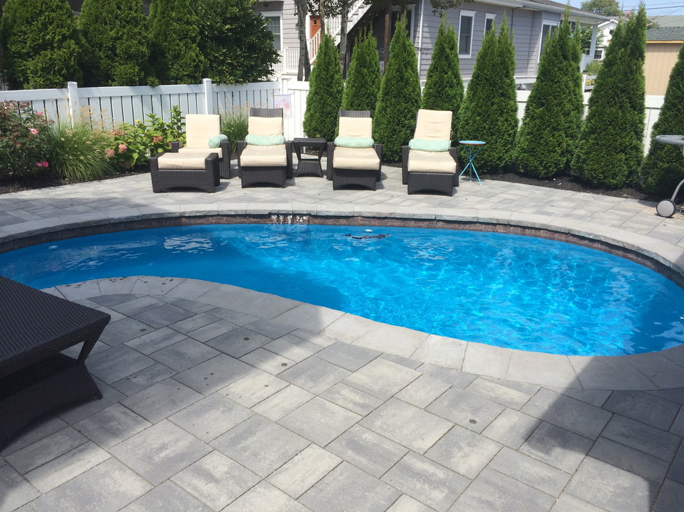 Mid-sized transitional backyard kidney-shaped lap pool in Philadelphia with concrete pavers.