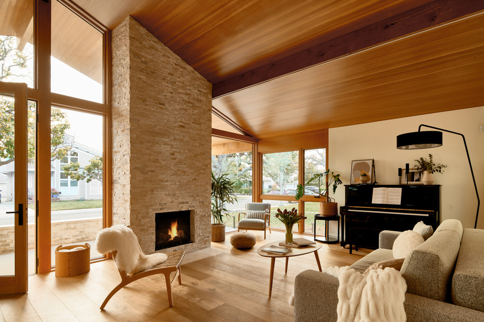 Midcentury living room in Los Angeles with white walls, medium hardwood floors, a standard fireplace, a brick fireplace surround, no tv, brown floor, exposed beam, vaulted and wood.