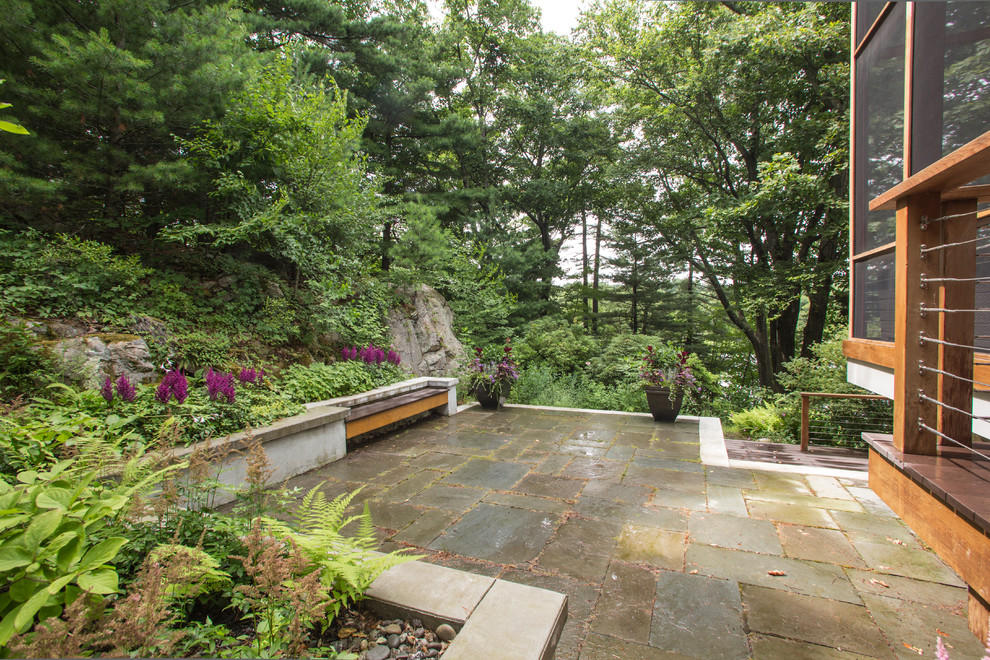 Photo of a large contemporary backyard patio in Boston with no cover and concrete slab.