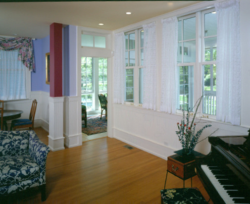 Cette photo montre un grand salon chic ouvert avec un mur blanc, un sol en bois brun et une cheminée standard.