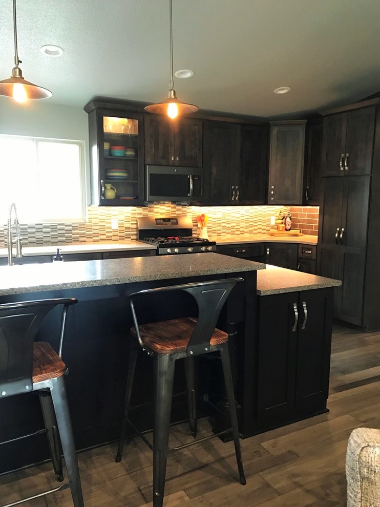 Mid-sized transitional single-wall light wood floor open concept kitchen photo with shaker cabinets, dark wood cabinets, multicolored backsplash, glass tile backsplash, stainless steel appliances, an island, a farmhouse sink and granite countertops
