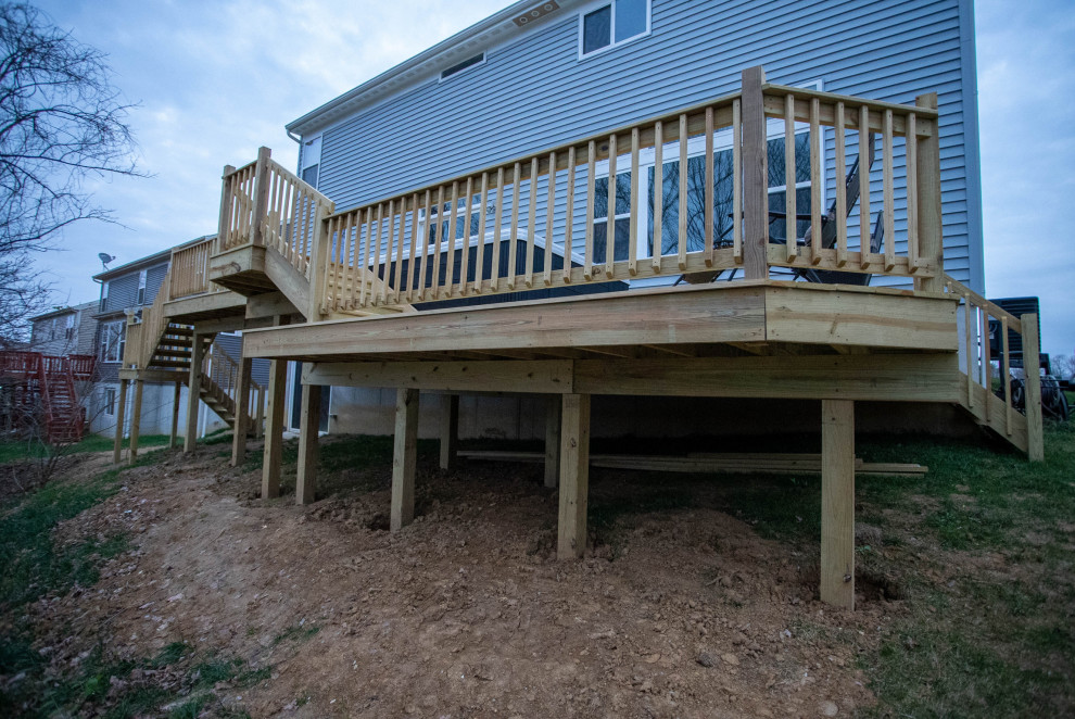 Mid-sized arts and crafts backyard and ground level deck in Cincinnati with wood railing.