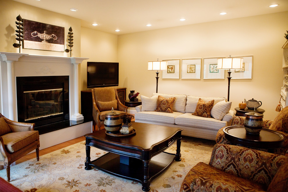 Inspiration for a mid-sized traditional formal open concept living room in Birmingham with beige walls, medium hardwood floors, a standard fireplace, a tile fireplace surround, a freestanding tv and brown floor.