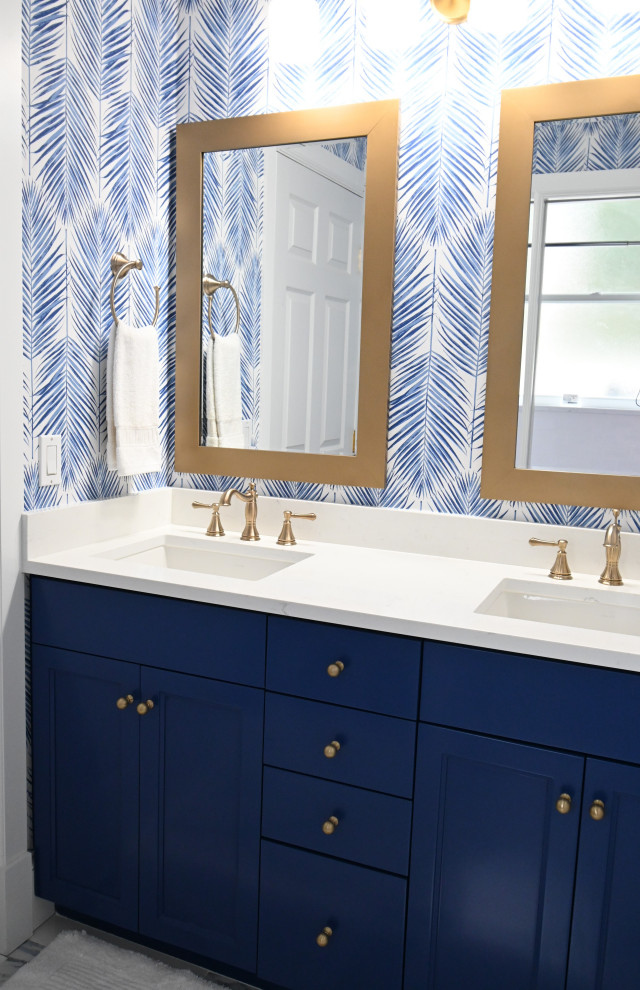 Идея дизайна: детская ванная комната среднего размера в морском стиле с фасадами с утопленной филенкой, синими фасадами, ванной в нише, раздельным унитазом, белой плиткой, керамической плиткой, разноцветными стенами, полом из керамической плитки, врезной раковиной, столешницей из кварцита, разноцветным полом, белой столешницей, тумбой под две раковины, встроенной тумбой и обоями на стенах