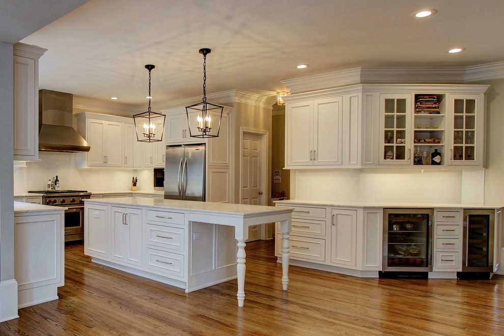 Kitchen pantry - large transitional u-shaped light wood floor kitchen pantry idea in Atlanta with an undermount sink, recessed-panel cabinets, white cabinets, quartz countertops, white backsplash, subway tile backsplash, stainless steel appliances and an island