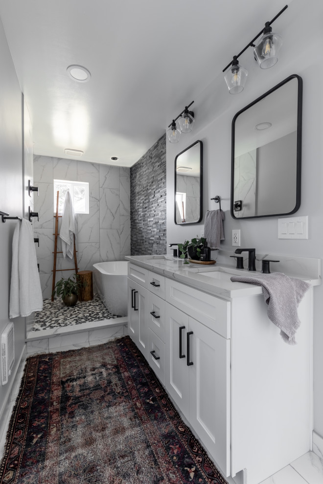 Photo of a mid-sized contemporary master bathroom in Seattle with shaker cabinets, blue cabinets, a freestanding tub, a shower/bathtub combo, a one-piece toilet, white tile, porcelain tile, grey walls, porcelain floors, an undermount sink, engineered quartz benchtops, white floor, an open shower, white benchtops, an enclosed toilet, a single vanity and a built-in vanity.