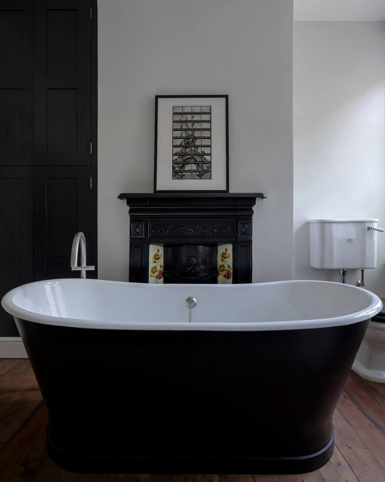 Photo of a mid-sized traditional kids bathroom in London with a freestanding tub, an open shower, a two-piece toilet, grey walls, medium hardwood floors, brown floor and an open shower.