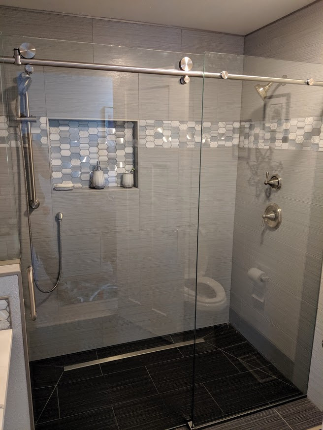 Inspiration for a mid-sized transitional 3/4 bathroom in Seattle with furniture-like cabinets, white cabinets, a curbless shower, gray tile, ceramic tile, grey walls, ceramic floors, a vessel sink, quartzite benchtops, black floor, a sliding shower screen and white benchtops.