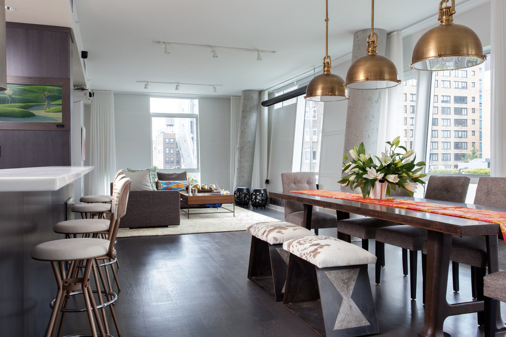 Photo of an industrial loft-style living room in New York with white walls and dark hardwood floors.