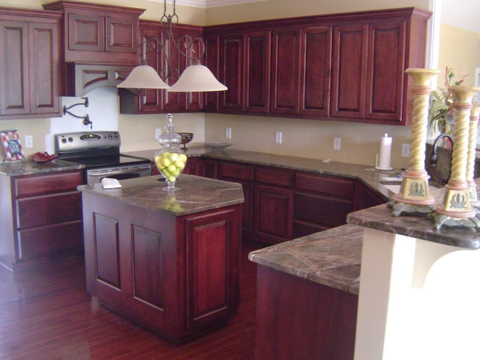 This is an example of a large traditional kitchen in Other with raised-panel cabinets, beige cabinets, granite benchtops, stainless steel appliances, dark hardwood floors and with island.