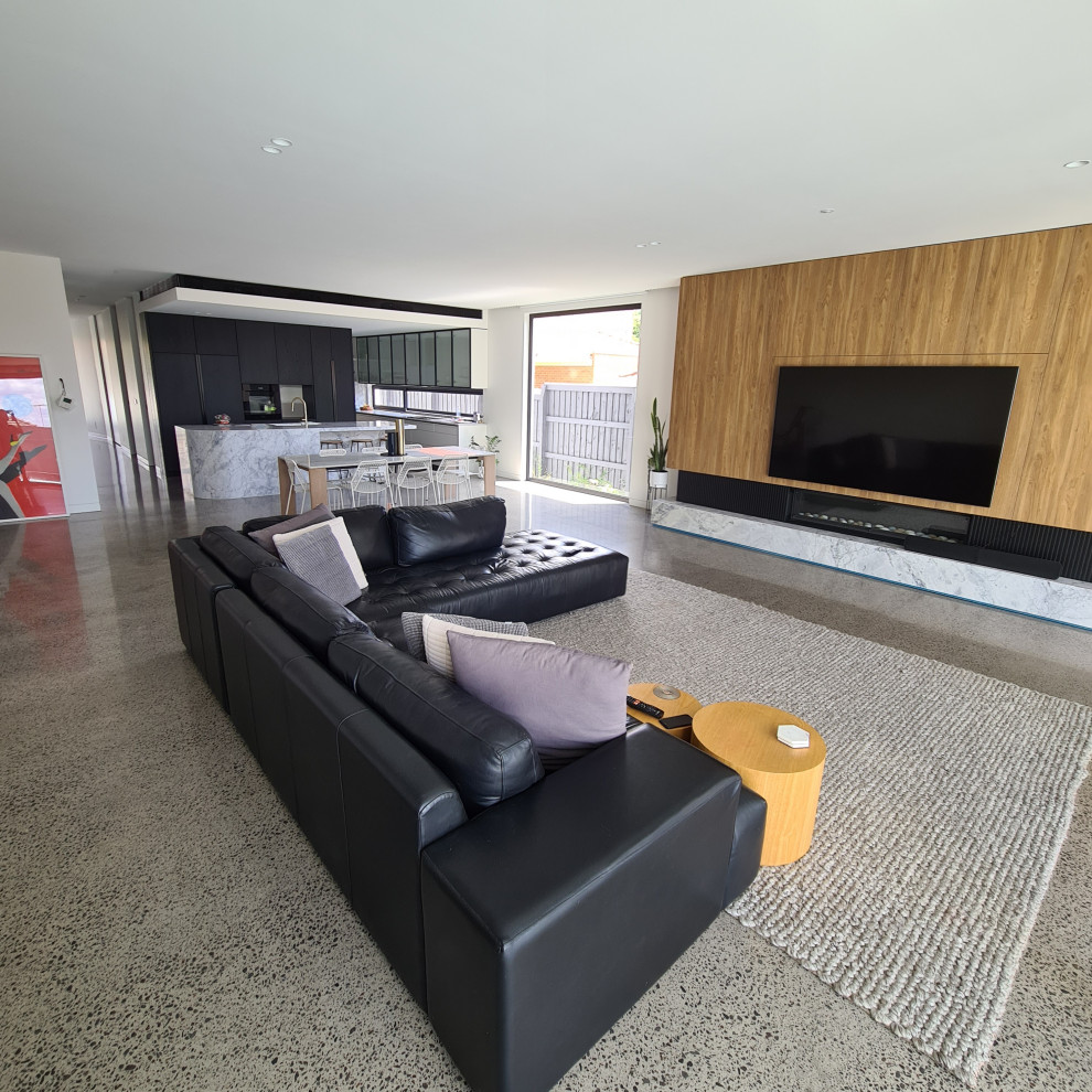 Großes, Offenes Modernes Wohnzimmer mit weißer Wandfarbe, Laminat, Gaskamin, Kaminumrandung aus Stein, Multimediawand und grauem Boden in Melbourne