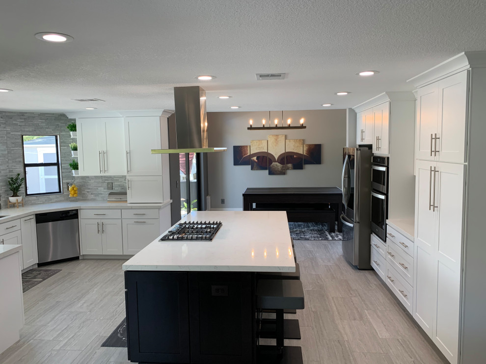 Example of a mid-sized transitional single-wall eat-in kitchen design in Las Vegas with shaker cabinets, white cabinets, quartz countertops, stainless steel appliances, an island and white countertops