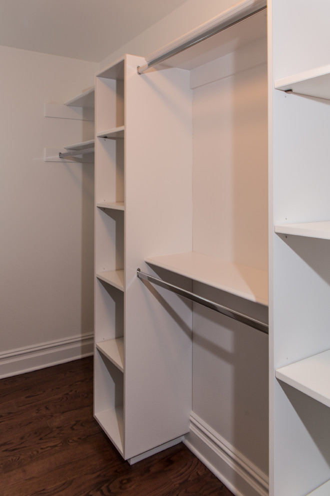 Design ideas for a large contemporary gender-neutral walk-in wardrobe in New York with white cabinets and medium hardwood floors.