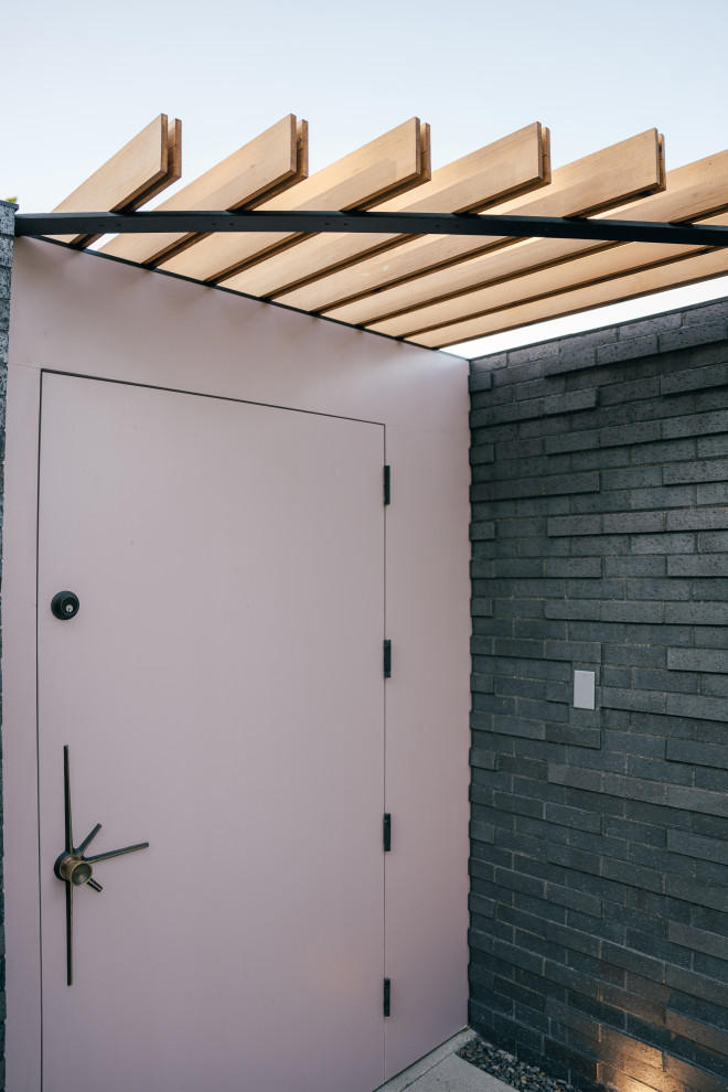 Idée de décoration pour une petite porte d'entrée avec un mur noir, sol en béton ciré, une porte simple, une porte violette, un sol gris, un plafond en bois et un mur en parement de brique.