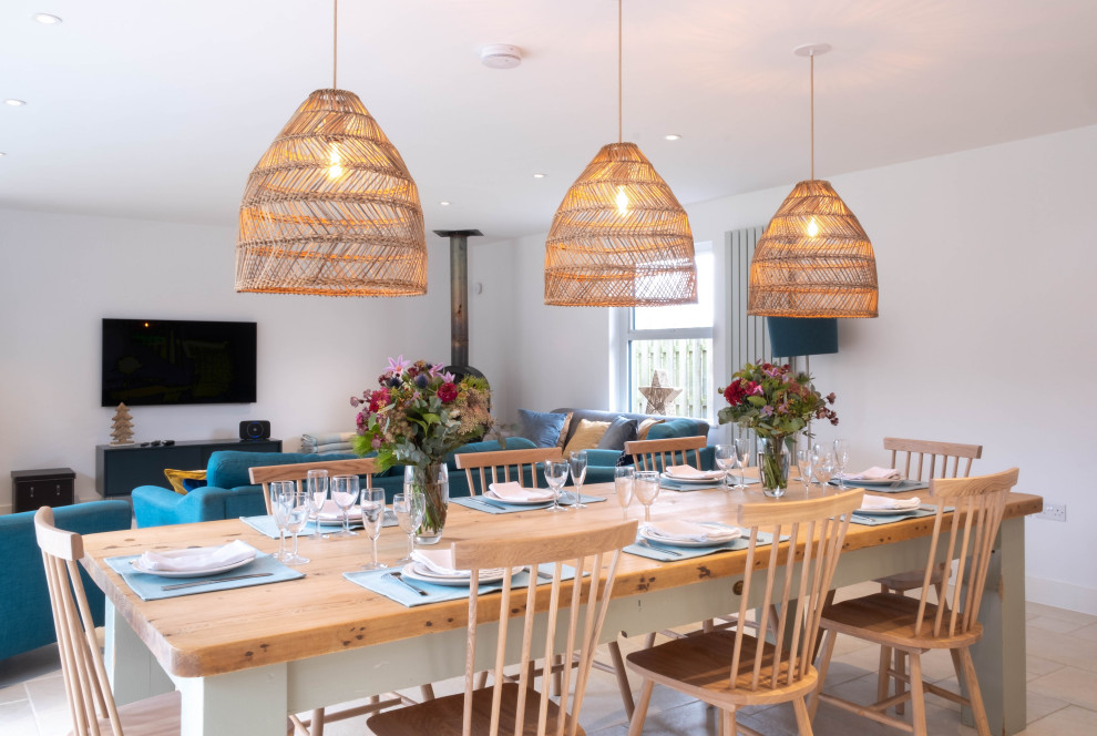 Esempio di una sala da pranzo aperta verso il soggiorno stile rurale di medie dimensioni con pareti bianche, pavimento in gres porcellanato, stufa a legna e pavimento beige