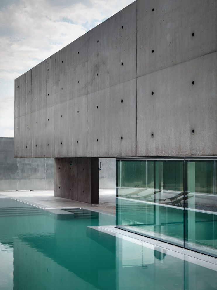This is an example of a mid-sized contemporary side yard custom-shaped pool in Milan with concrete slab.