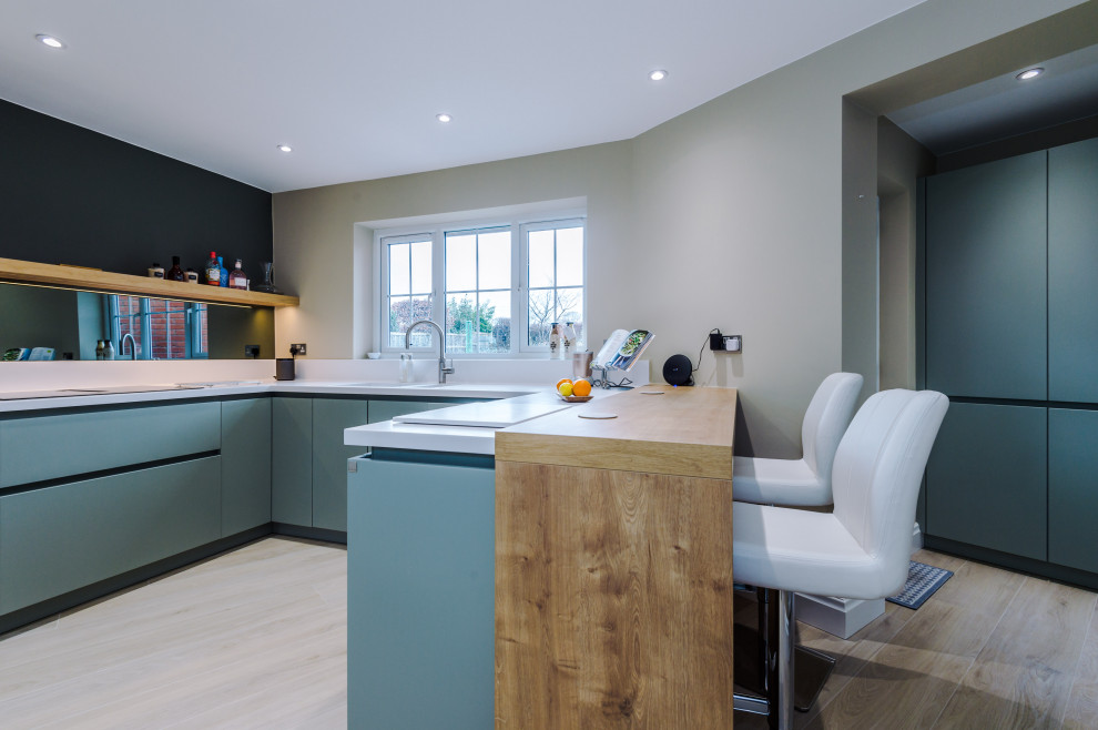 Foto di una cucina ad U contemporanea di medie dimensioni con lavello da incasso, ante blu e pavimento in gres porcellanato