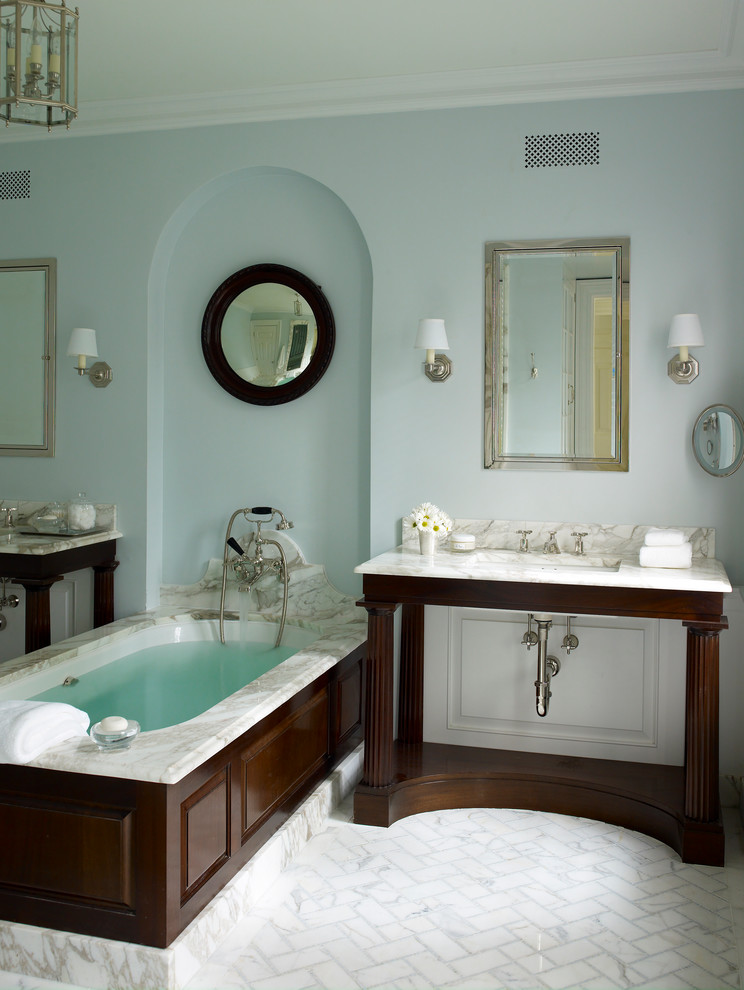 Design ideas for a large modern master bathroom in Bridgeport with dark wood cabinets, a drop-in tub, a shower/bathtub combo, white tile, stone tile, blue walls, porcelain floors, an undermount sink and marble benchtops.